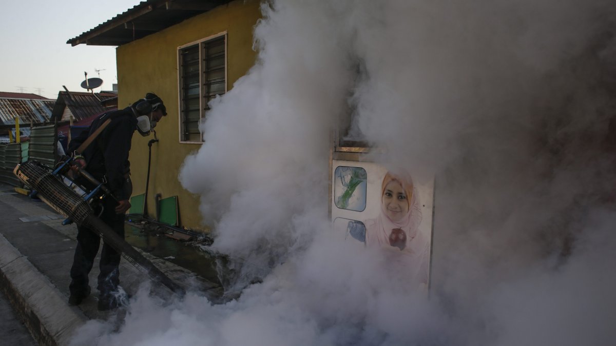 Un trabajador de salud fumiga para prevenir el contagio de dengue en un suburbio de Kuala Lumpur