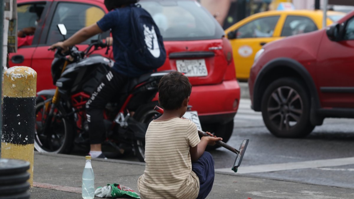 Un menor en edad escolar se dedica a limpiar parabrisas en una calle del centro de Guayaquil.