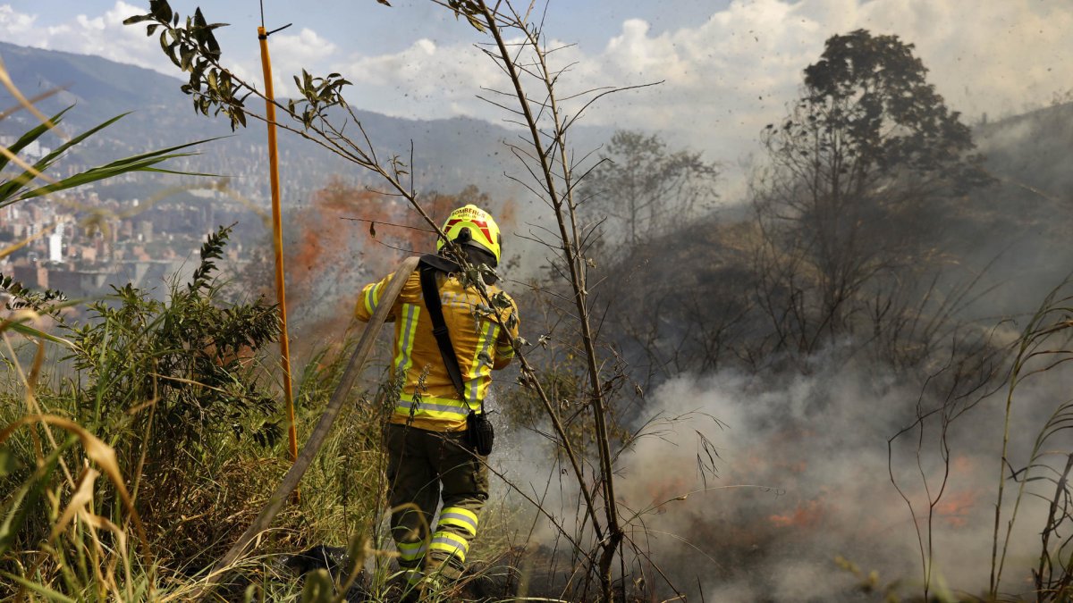 Fotografía de archivo de bomberos mientras combaten un incendio forestal, en Medellín (Colombia).