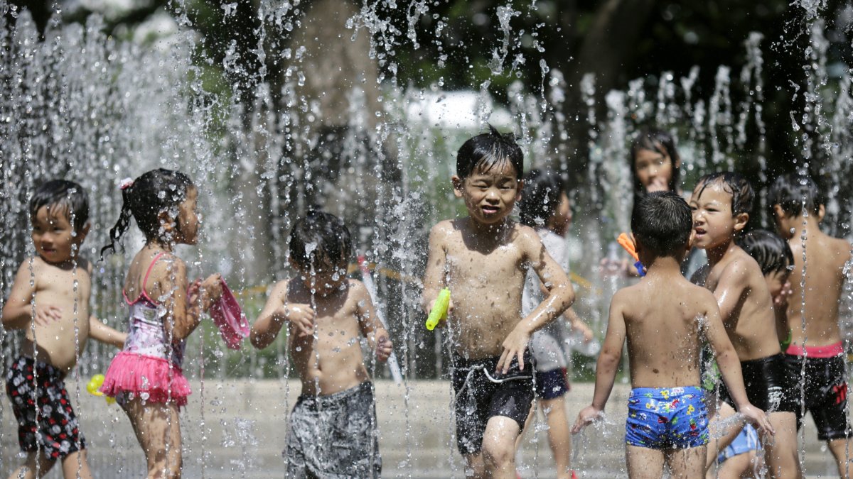 Tokio. Niños se refrescan en una fuente de la capital de Japón.