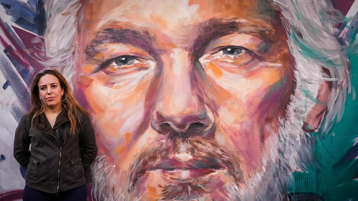 Stella Moris, mujer de Julian Assange, posando junto a un mural pintado en honor de su marido.