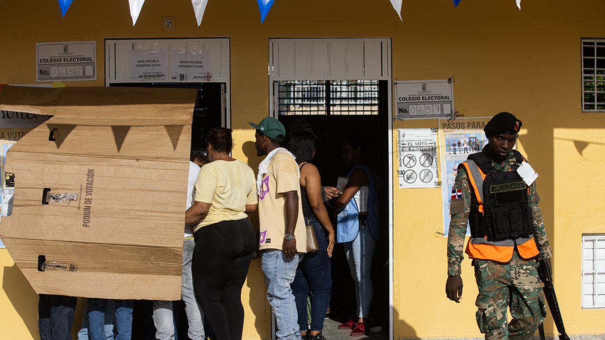 Votantes se protegen del sol en un centro de votación luego de una jornada de elecciones en Santo Domingo (República Dominicana). 