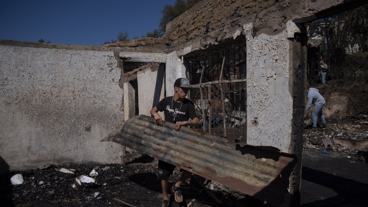 Personas retiran escombros este jueves de las viviendas destruidas por el incendio que afectó al Cerro Cordillera en Valparaíso (Chile).