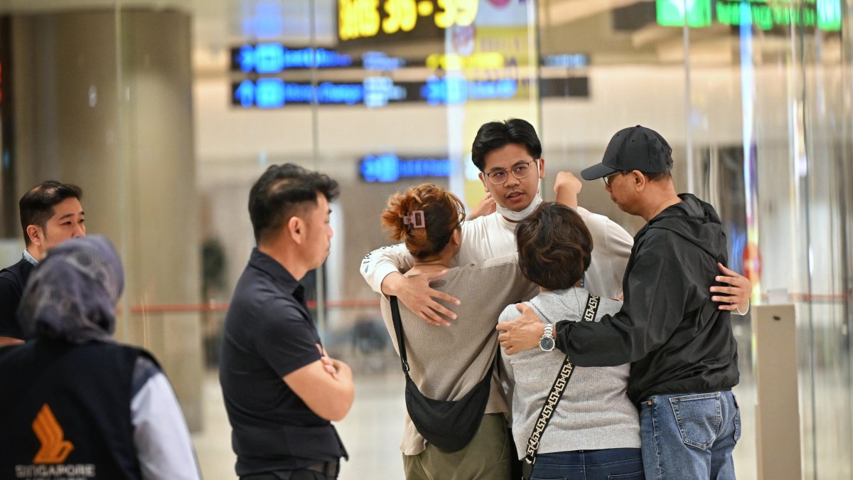 Pasajeros del vuelo de Singapore Airlines son recibidos por sus familiares, luego de que sufrió fuertes turbulencias el martes llegaron a Singapur este miércoles 22 de mayo de 2024.