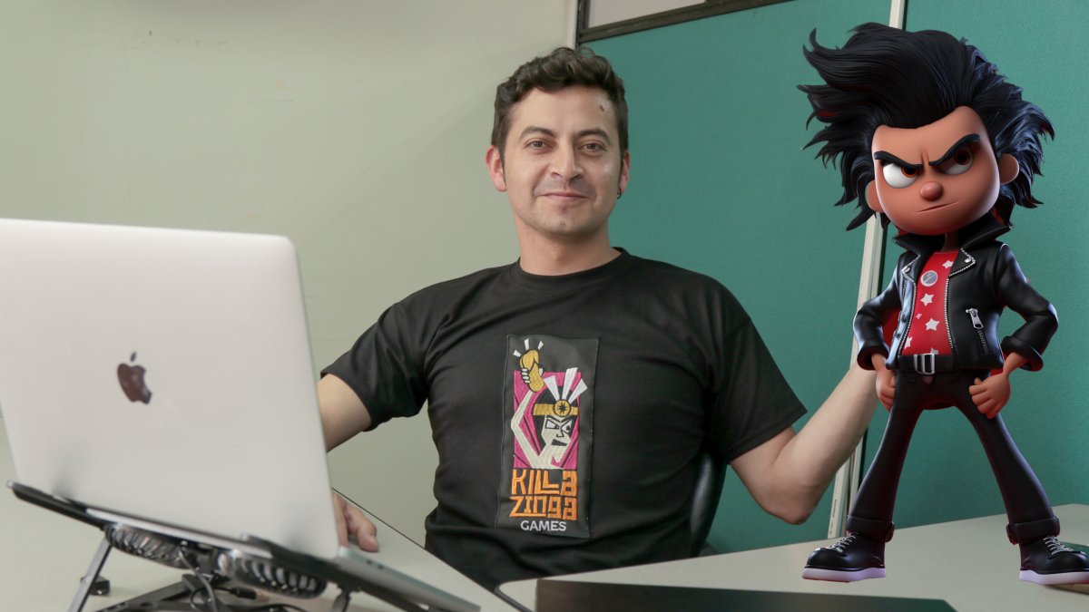 El diseñador ecuatoriano y director de Killa Zinga Games, Danny Oñate, posa con una representación del personaje protagonista del videojuego Capac Heroes.