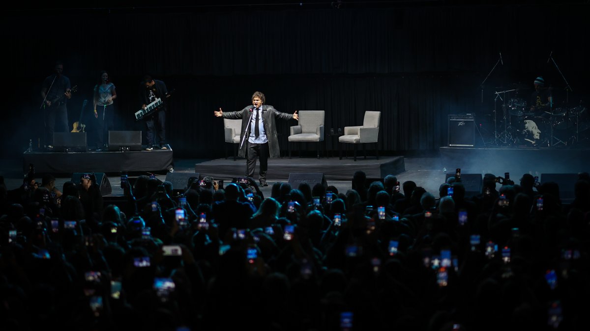 El presidente Javier Milei, interpreta una canción durante el lanzamiento de su libro 'Capitalismo, socialismo y la trampa neoclásica' este martes, en el estadio Luna Park en Buenos Aires.