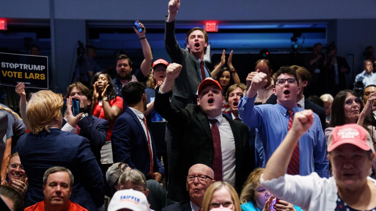 Los miembros de la multitud reaccionan mientras el expresidente estadounidense Donald Trump habla en la Convención Libertaria en Washington, DC.