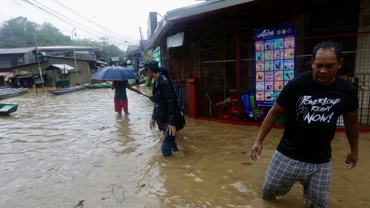 Aldeanos caminan en la ciudad de Pagsanjan, afectada por las inundaciones, provincia de Laguna, Filipinas, el 26 de mayo de 2024.