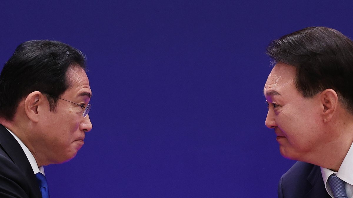 El presidente surcoreano, Yoon Suk Yeol (i), le da la mano al primer ministro japonés, Fumio Kishida, en la conferencia de prensa conjunta al margen de la Cumbre Trilateral.