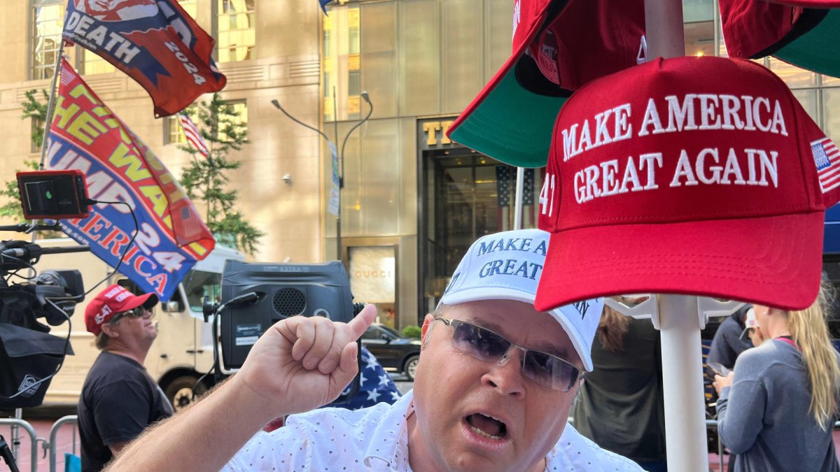 Un seguidor del expresidente Donald Trump grita consignas frente a una cámara mientras sostiene una gorra de 'Haz a los Estados Unidos grande otra vez' en Nueva York.