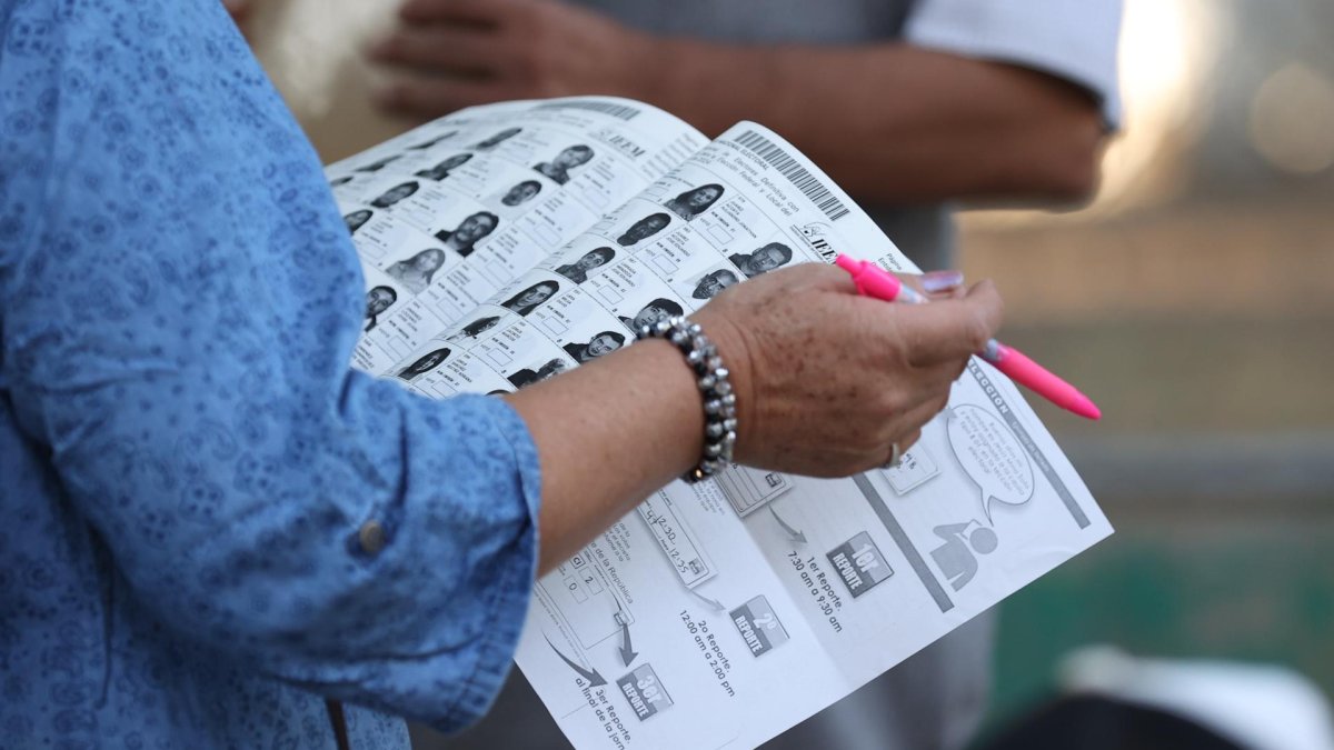 Una funcionaria de casilla revisa una lista electoral para las votaciones este domingo, en la Ciudad de México.