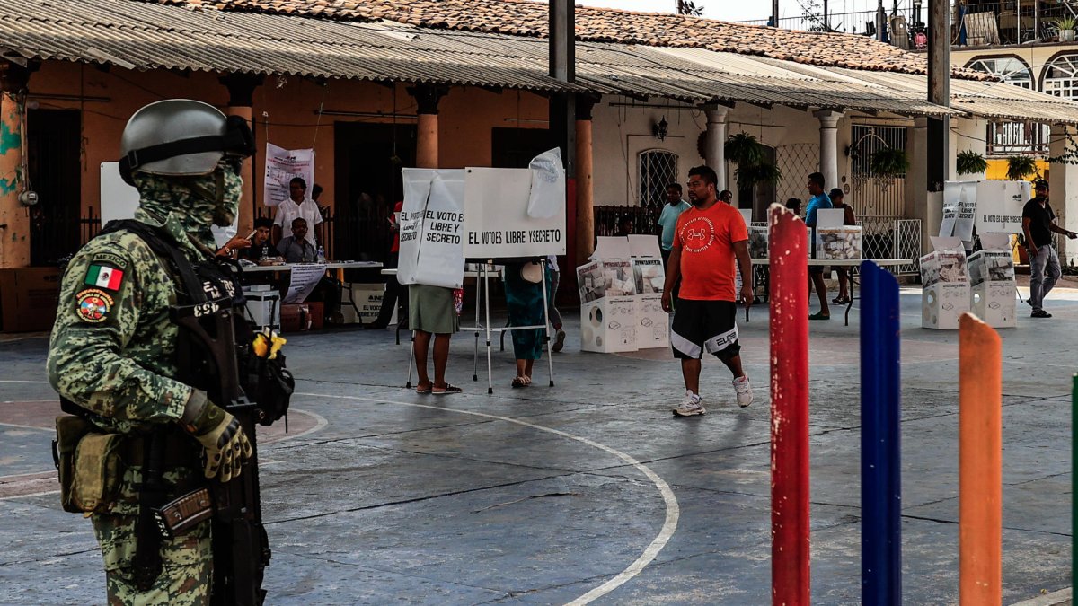 Miembros del Ejercito Mexicano resguardan a ciudadanos que emiten su voto en las elecciones generales mexicanas este domingo.