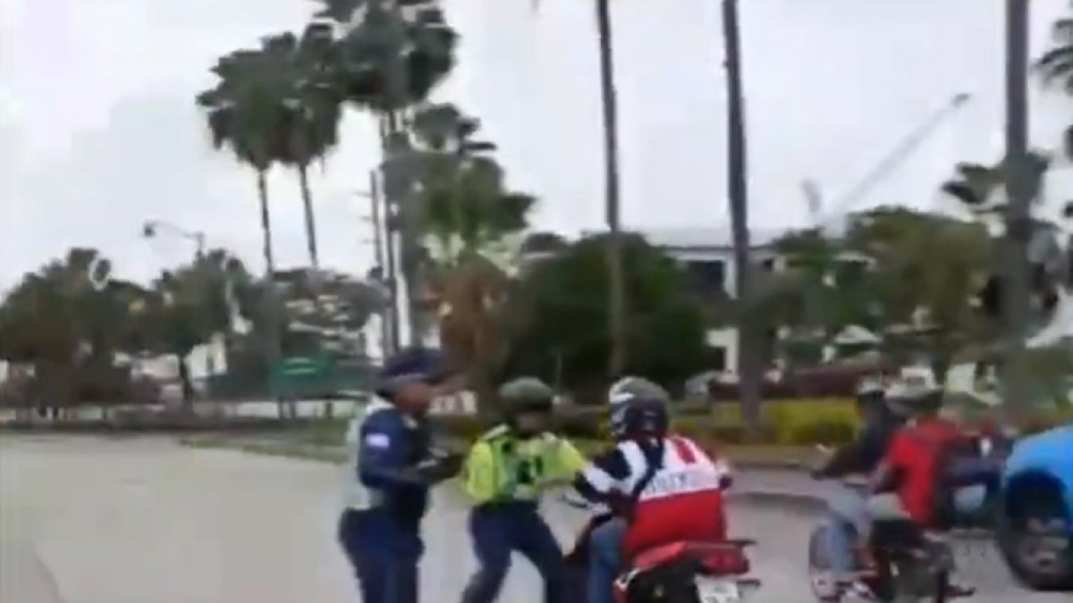 Momento en el que el agente intentó, sin suerte, de detener al motociclista.
