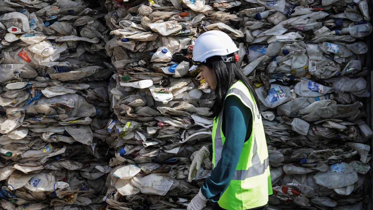 una empleada camina junto a un contenedor repleto de plástico en Puerto Klang en Selangor.