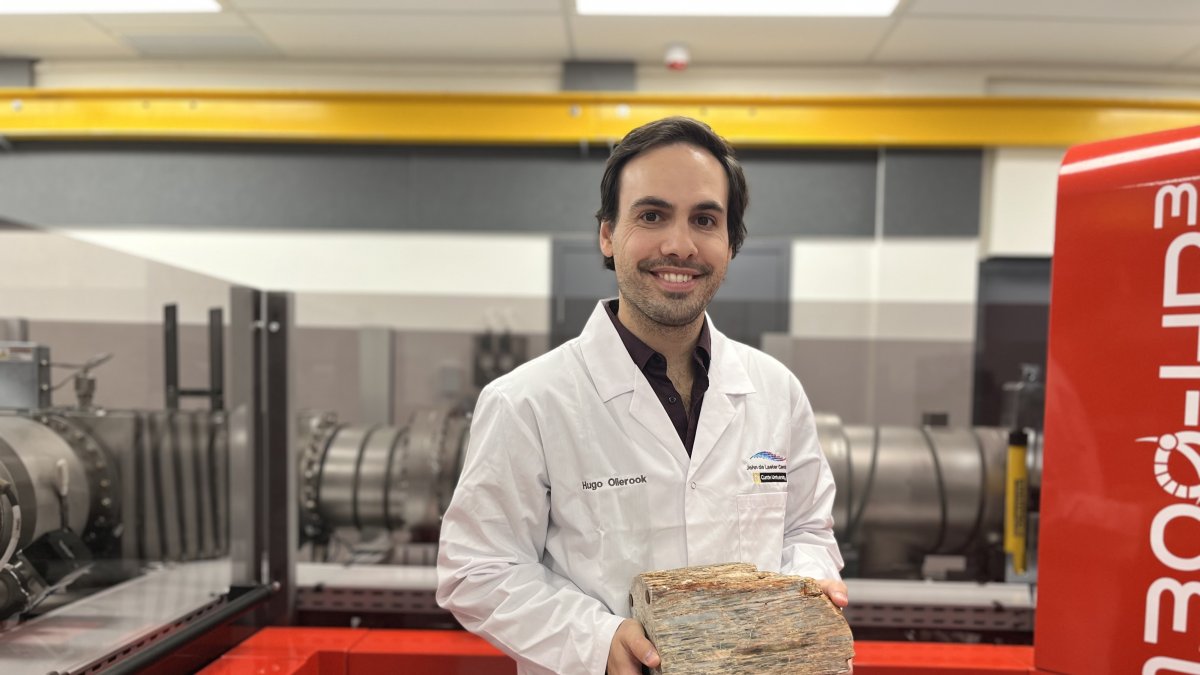 El investigador de la Universidad australiana de Curtin, Hugo Olierook, nuestra una roca que contiene un mineral llamado circón.