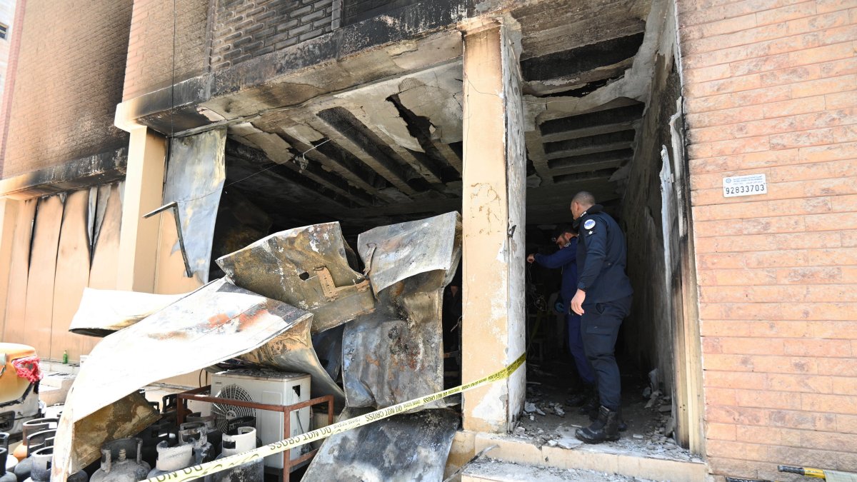 Las fuerzas de seguridad kuwaitíes inspeccionan el edificio residencial después de que se produjera un incendio en el sur de la gobernación de Ahmadi, Kuwait, el 12 de junio de 2024.