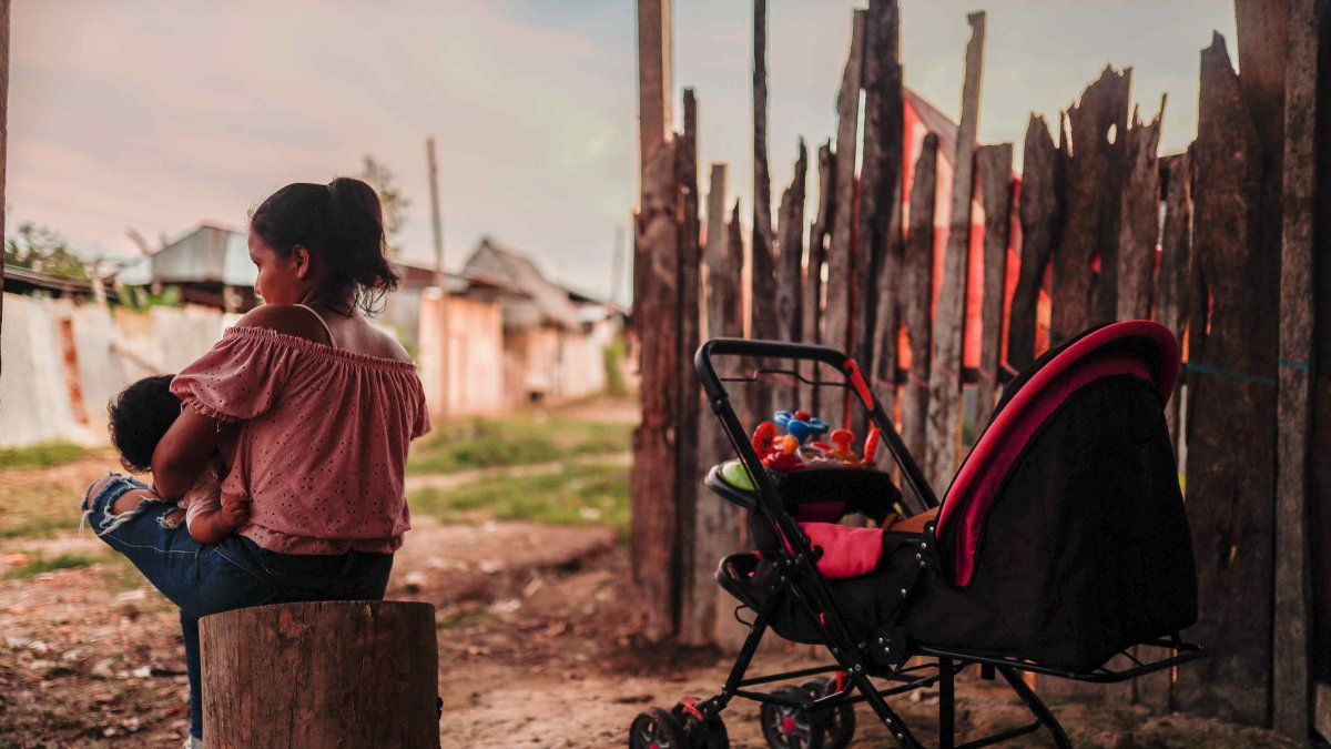 Una madre adolescente sentada con su hijo en Iquitos (Perú)