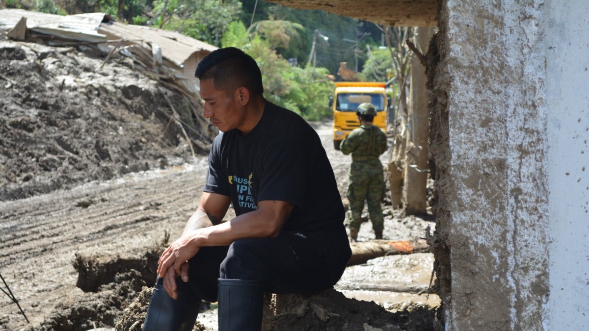 Luis Chango, sentado frente a la casa dónde murieron cuatro integrantes de su familia.