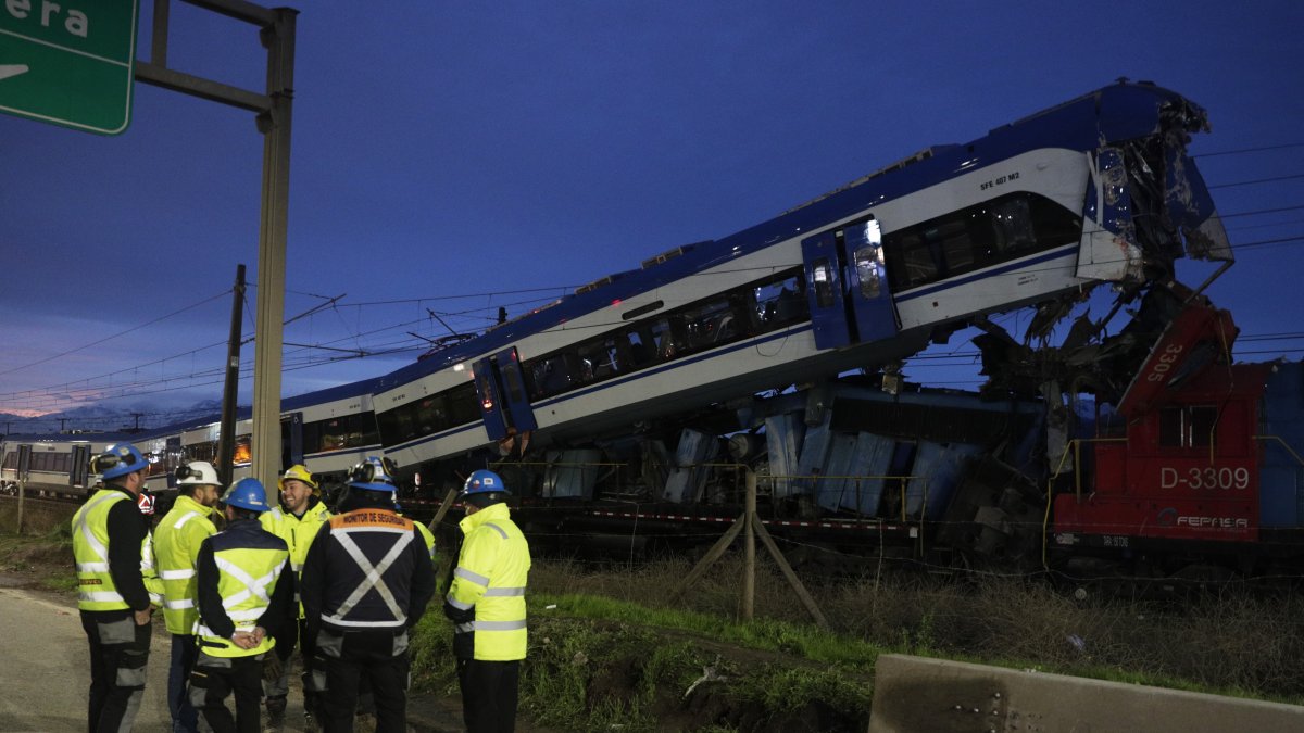 Personal de seguridad reacciona junto a las dos trenes involucrados en un accidente en la madrugada de este jueves, en la comuna de San Bernardo, en el sur de Santiago (Chile).
