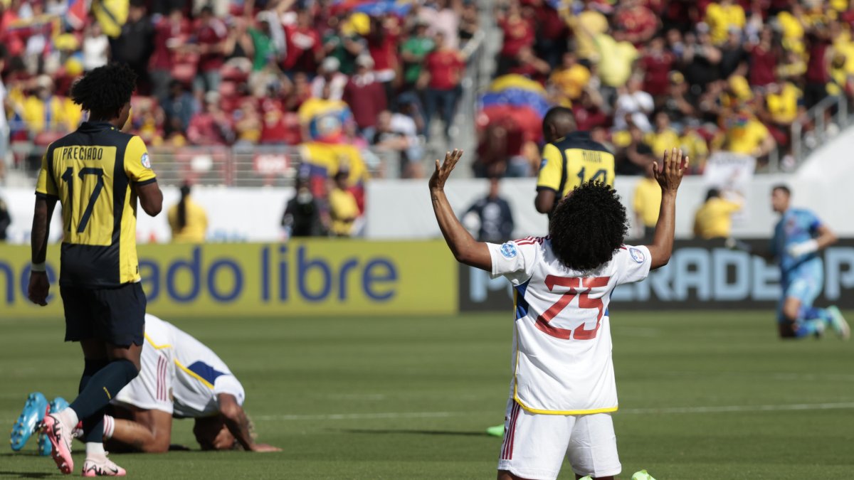 Angelo Preciado (i) camina cabizbajo ante el festejo de un venezolano.