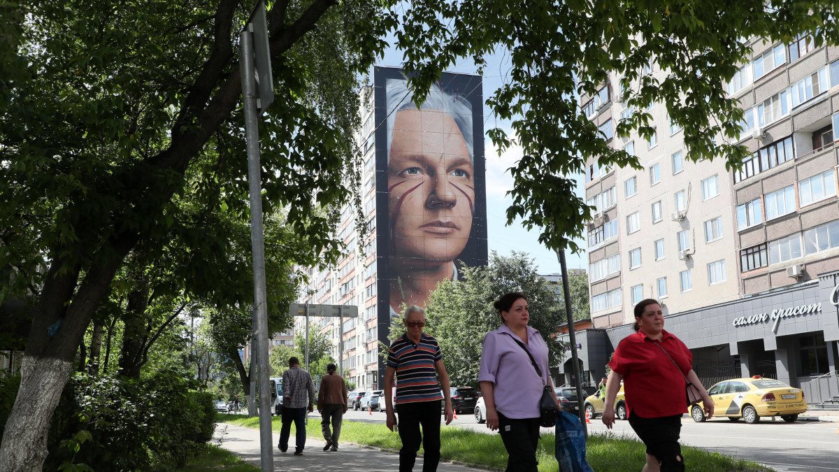 Moscú. La gente pasa junto a un mural del fundador de WikiLeaks.