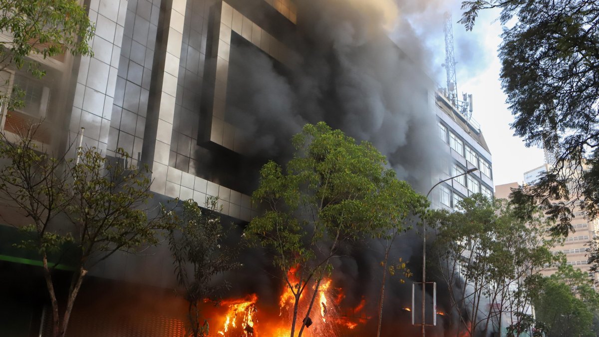 Llamas y humo salen de un centro comercial en llamas durante una protesta cerca del Parlamento contra los aumentos de impuestos, en Nairobi, Kenia, el 25 de junio de 2024.