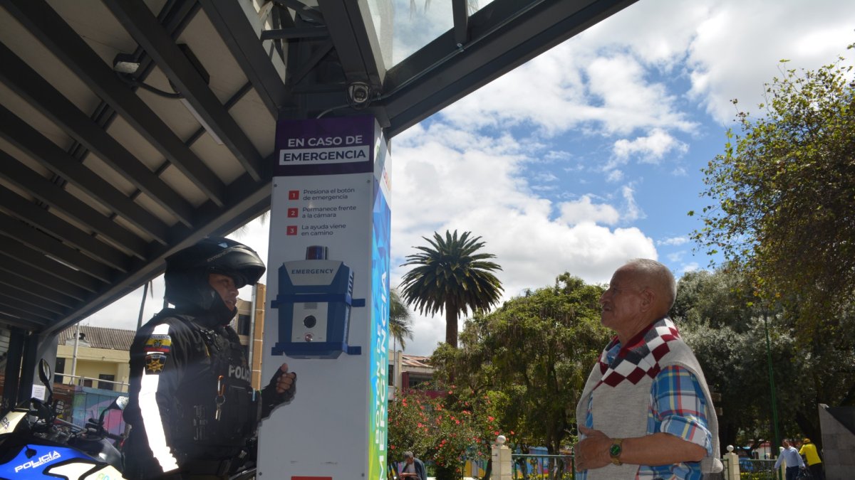Atención. Un policía explica a un ciudadano cómo pedir ayuda a través de la alarma ubicada en un parque.