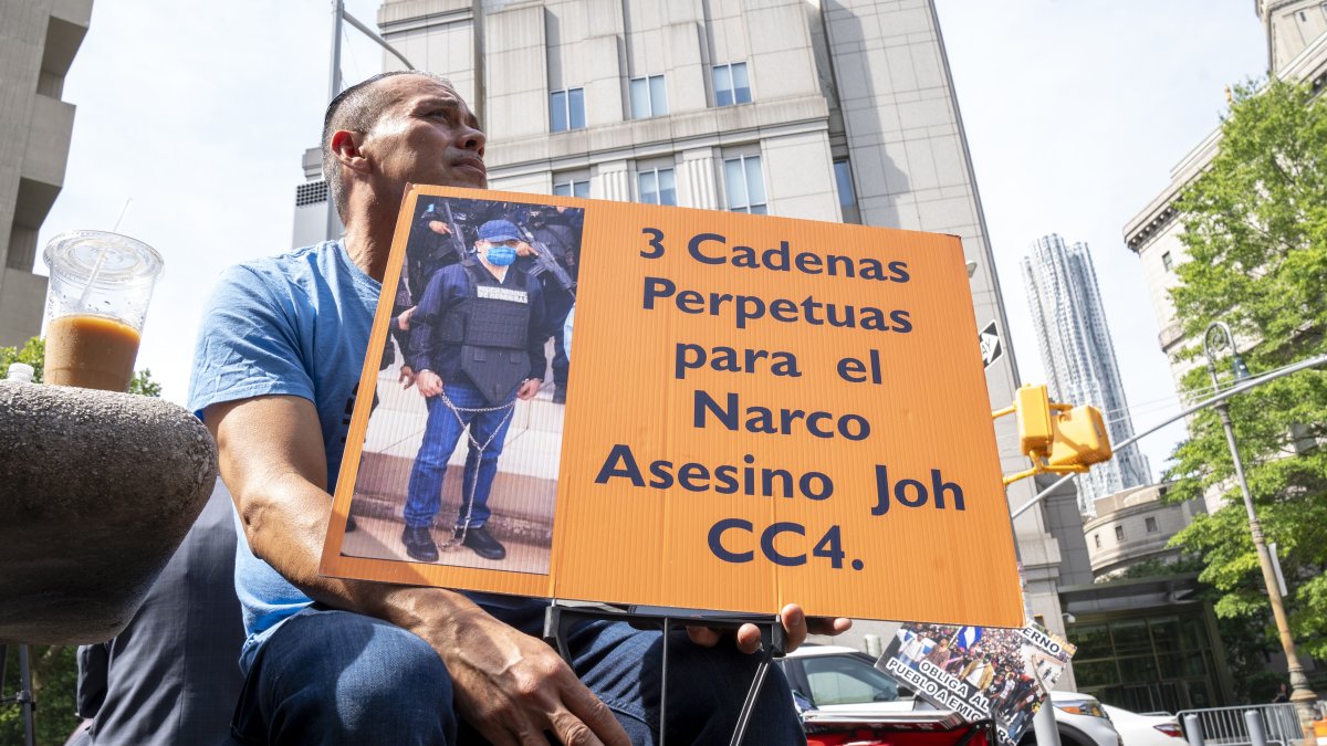 Un hombre sostiene una pancarta que pide 