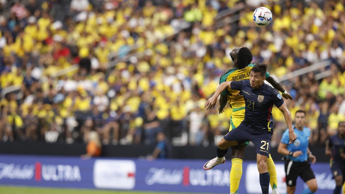 El delantero de Jamaica Shamar Nicholson (L) y el mediocampista de Ecuador Alan Franco (R) desafían el balón durante la primera mitad del partido.