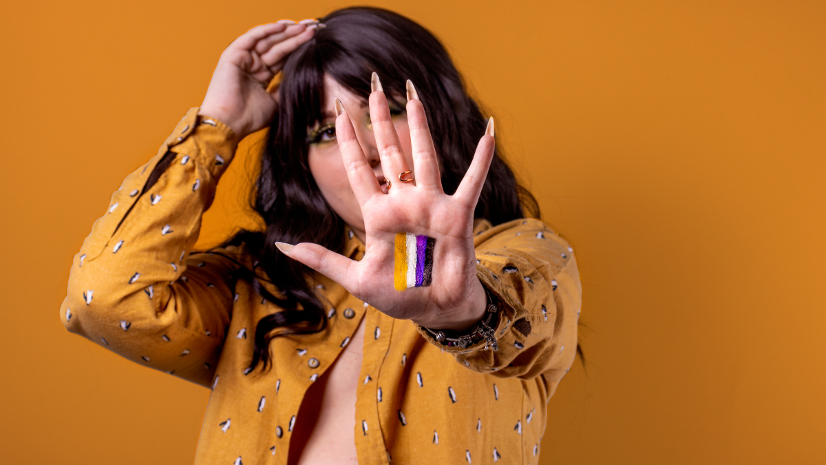 Persona mostrando la bandera del género no binario.