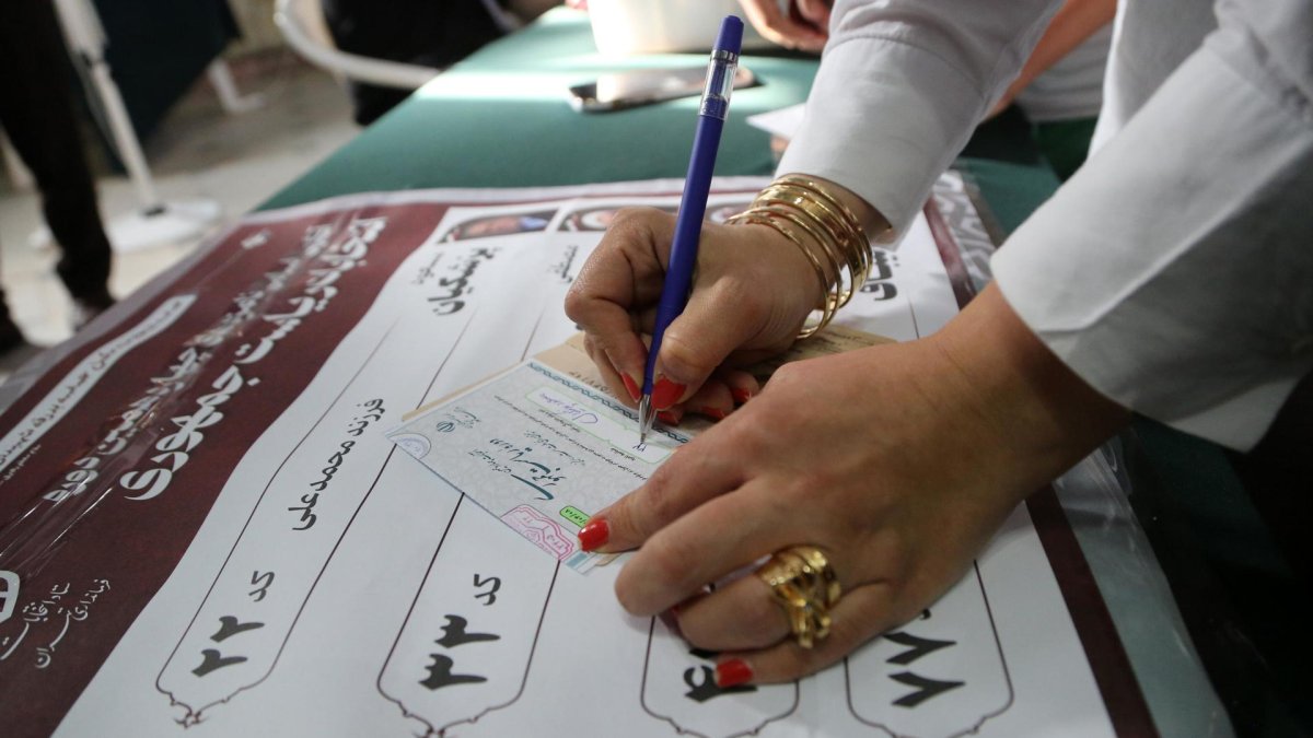 Una mujer iraní rellena la papeleta de voto en un colegio electoral durante las elecciones presidenciales, en Teherán, Irán, el 28 de junio de 2024.