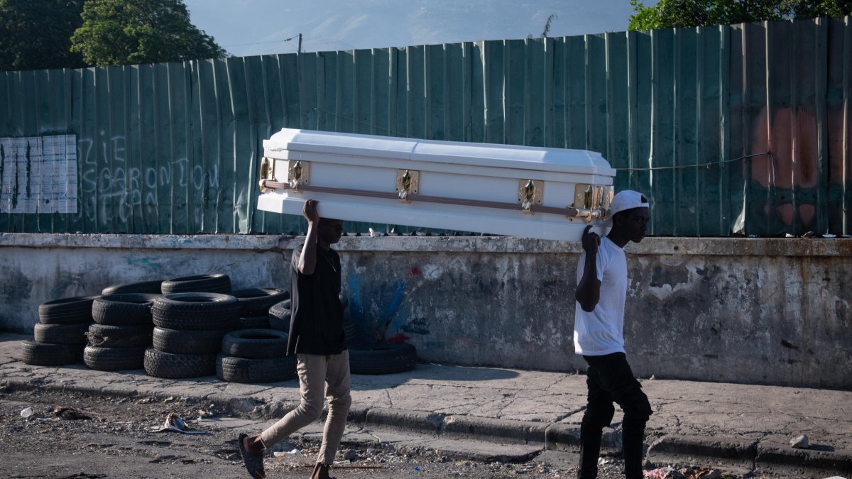 Puerto Príncipe. Dos hombres cargan ataúd por una calle de esta capital.