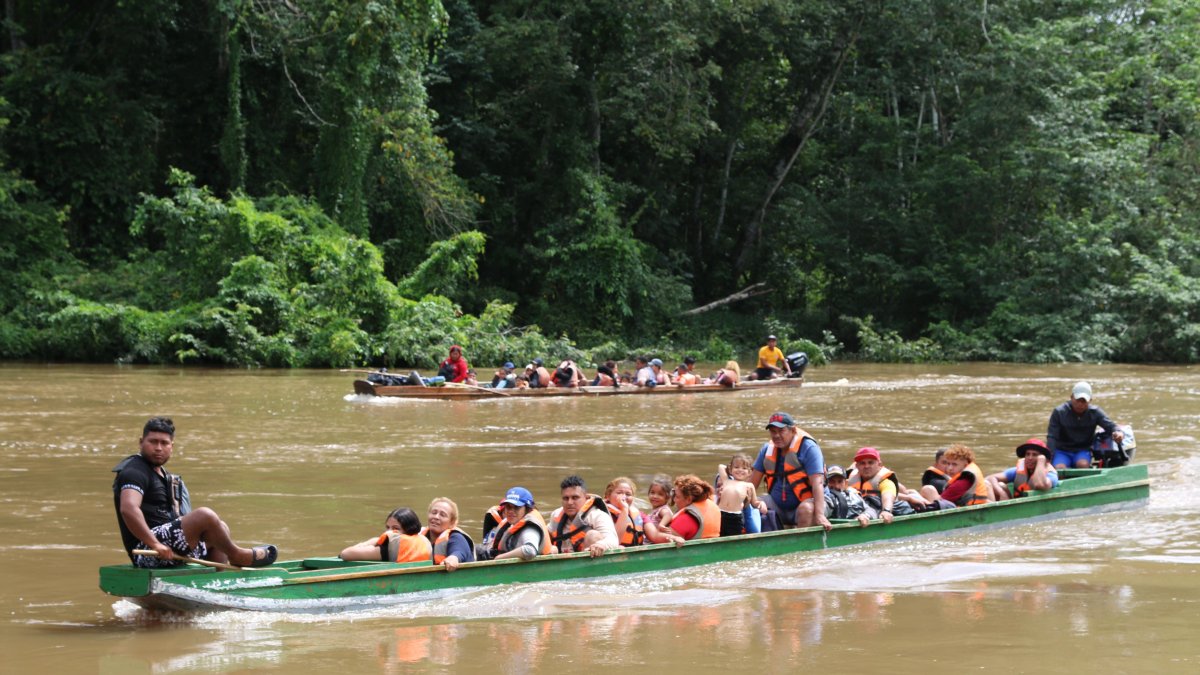 Migrantes llegan en canoa por el río Tuquesa desde el poblado de Bajo Chiquito hasta el centro de recepción de Lajas Blancas en el Darién.