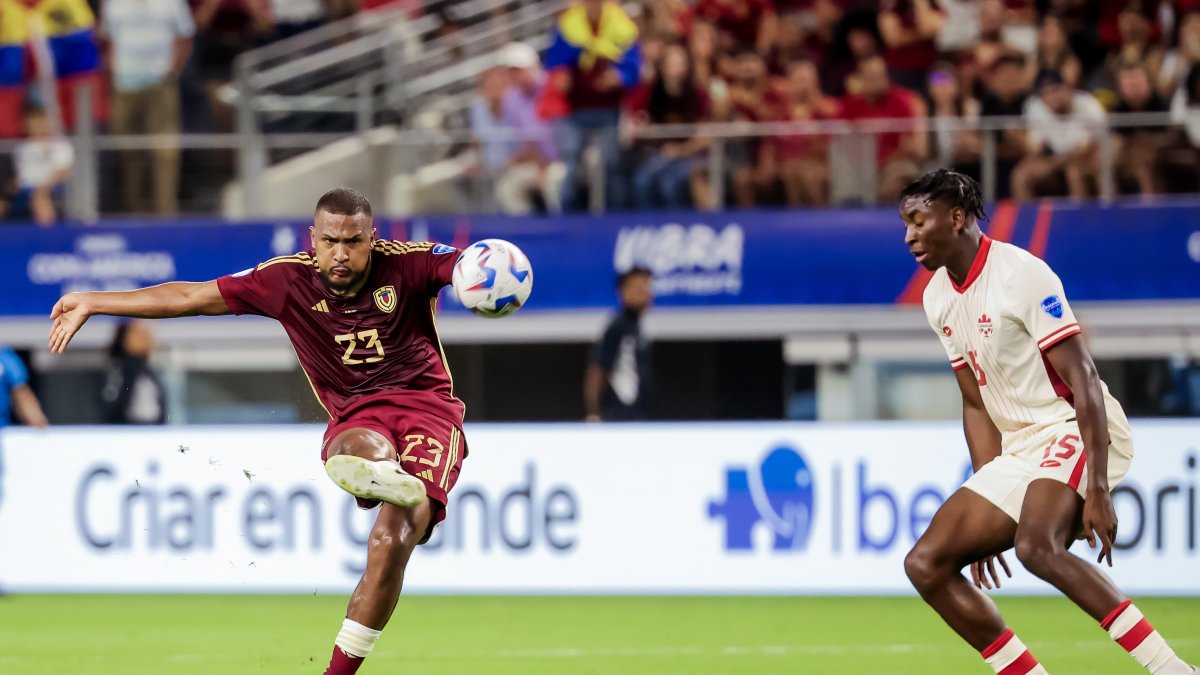 José Salomón Rondón (Izq.) de Venezuela anota el gol del empate 1-1 contra Moise Lumpungu (Der.) de Canadá durante la segunda mitad de la Copa América 2024.