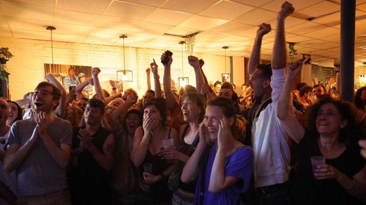 La gente reacciona ante el anuncio de la victoria en las elecciones parlamentarias del Nuevo Frente Popular.