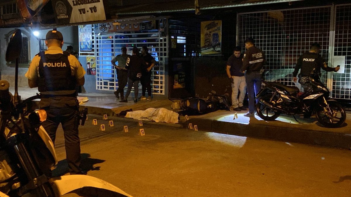 Policías y curiosos observan el lugar donde ocurrió el crimen.