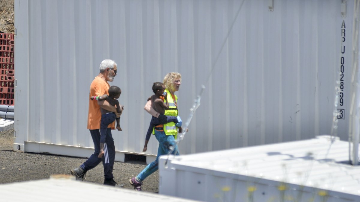 El Hierro (España). Miembros de los Servicios de emergencias llevan dos niños que llegaron en una patera.
