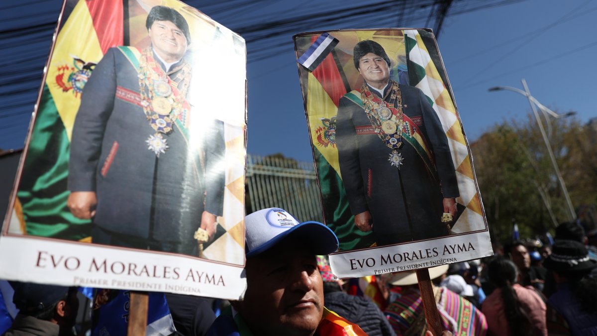 Seguidores del expresidente de Bolivia y líder del Movimiento al Socialismo (MAS), Evo Morales, sostienen carteles de apoyo afuera de la sede del Tribunal Supremo Electoral.