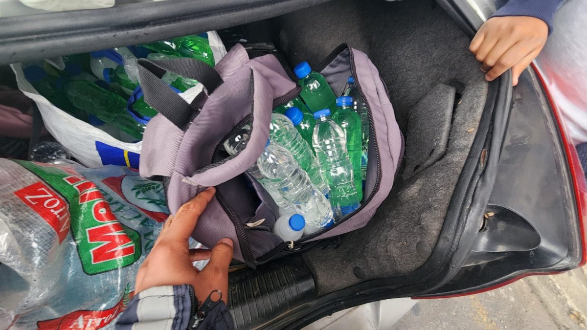 En el auto había alrededor de 150 botellas de licor en colores azul, verde y blanco.