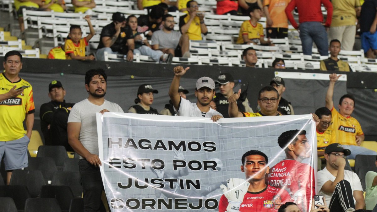Hinchas con un cartel que prometieron llevar en los demás partidos en homenaje a Justin Cornejo.