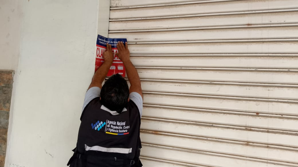 Personal de la Arcsa clausurando un local comercial.