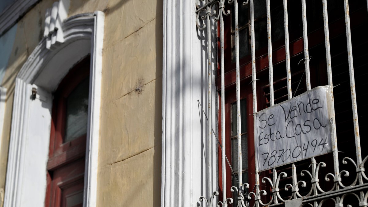 La fachada de una vivienda con cartel de 