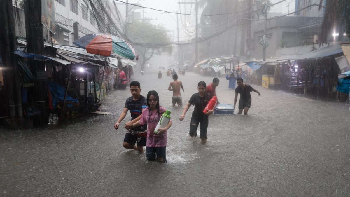 Residentes caminan en una zona inundada tras las lluvias monzónicas en Manila, Filipinas, el 24 de julio de 2024.