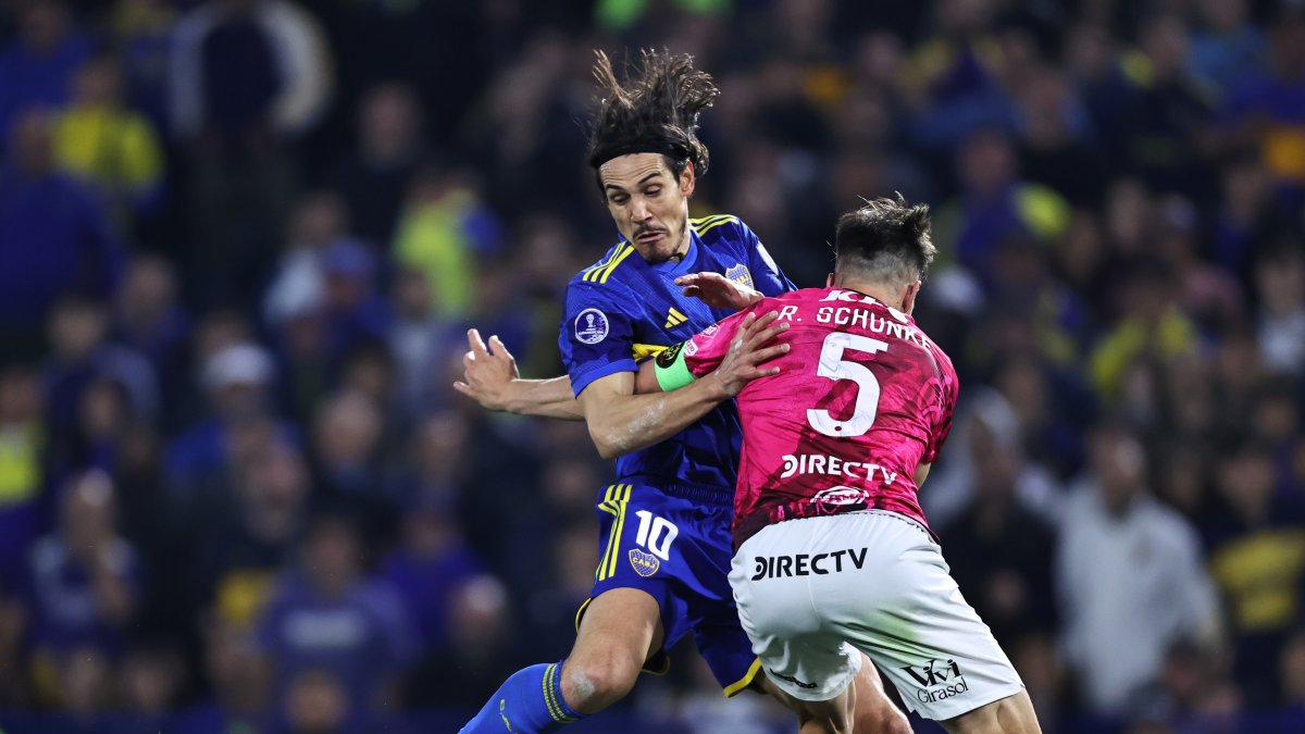 Edinson Cavani (i) de Boca disputa un balón con Richard Schunke de Independiente a un partido por la clasificación a los octavos de final de la Copa Sudamericana