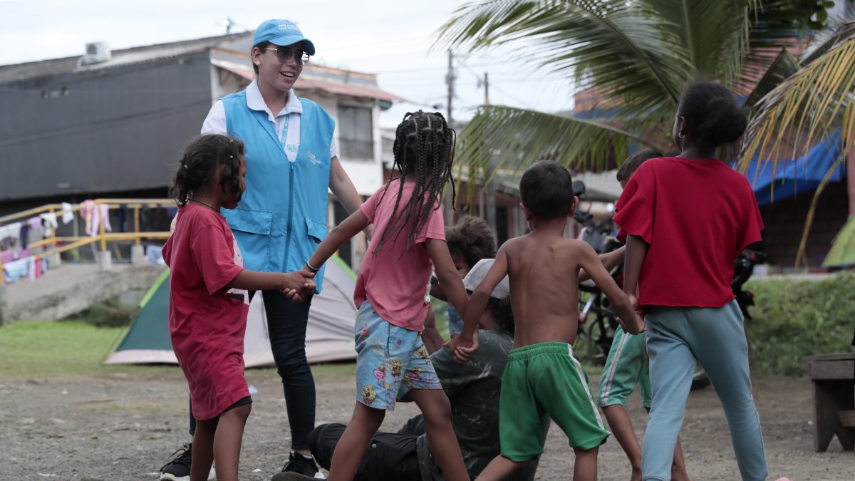 Una funcionaria de Aldeas Infantiles pinta la mano de una niña el 8 de julio de 2024 en Turbo.
