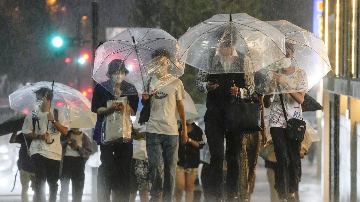 Tokio. Varias personas tratan de protegerse de la lluvia.