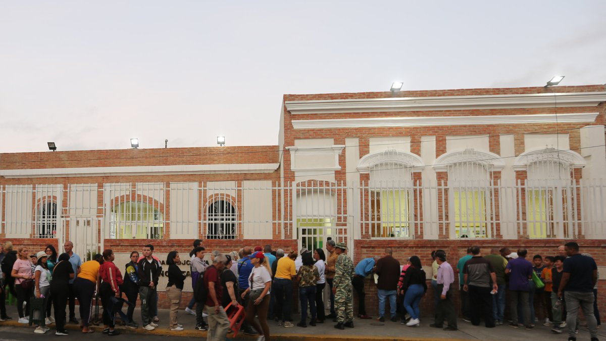 Ciudadanos esperan para votar este domingo, afuera de un centro de votación en Caracas (Venezuela).