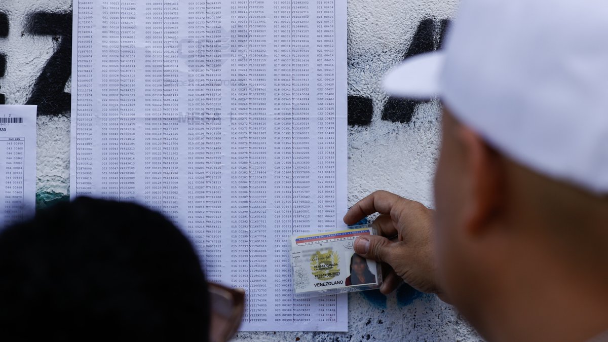 Un ciudadano venezolano busca su mesa de votación durante la jornada de elecciones presidenciales de Venezuela este domingo, en Caracas (Venezuela).