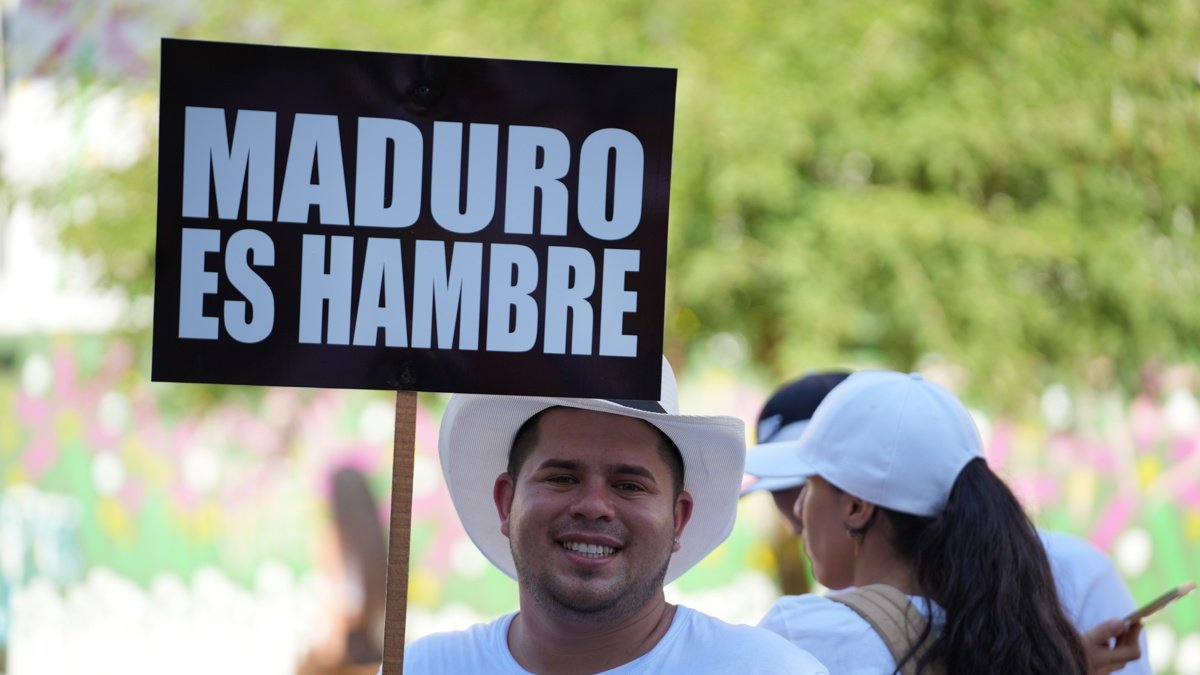 Un hombre sostiene un cartel contra el presidente de Venezuela Nicolás Maduro este domingo, en una concentración con motivo de las elecciones presidenciales en su país, este domingo en Cali (Colombia).