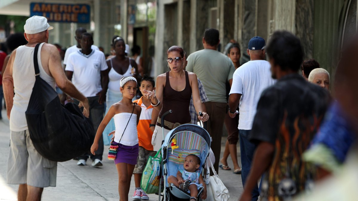 Una mujer que camina acompañada de sus niños por una calle de La Habana (Cuba).